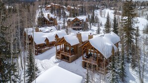 A lodge with multiple wooden cabins, each with a balcony and surrounded by snow-covered trees. - Lodge-Style Home by InvitedHome | Vast Patio, Hot Tub, Walk to Ski, Fireplace (Mountain Village)