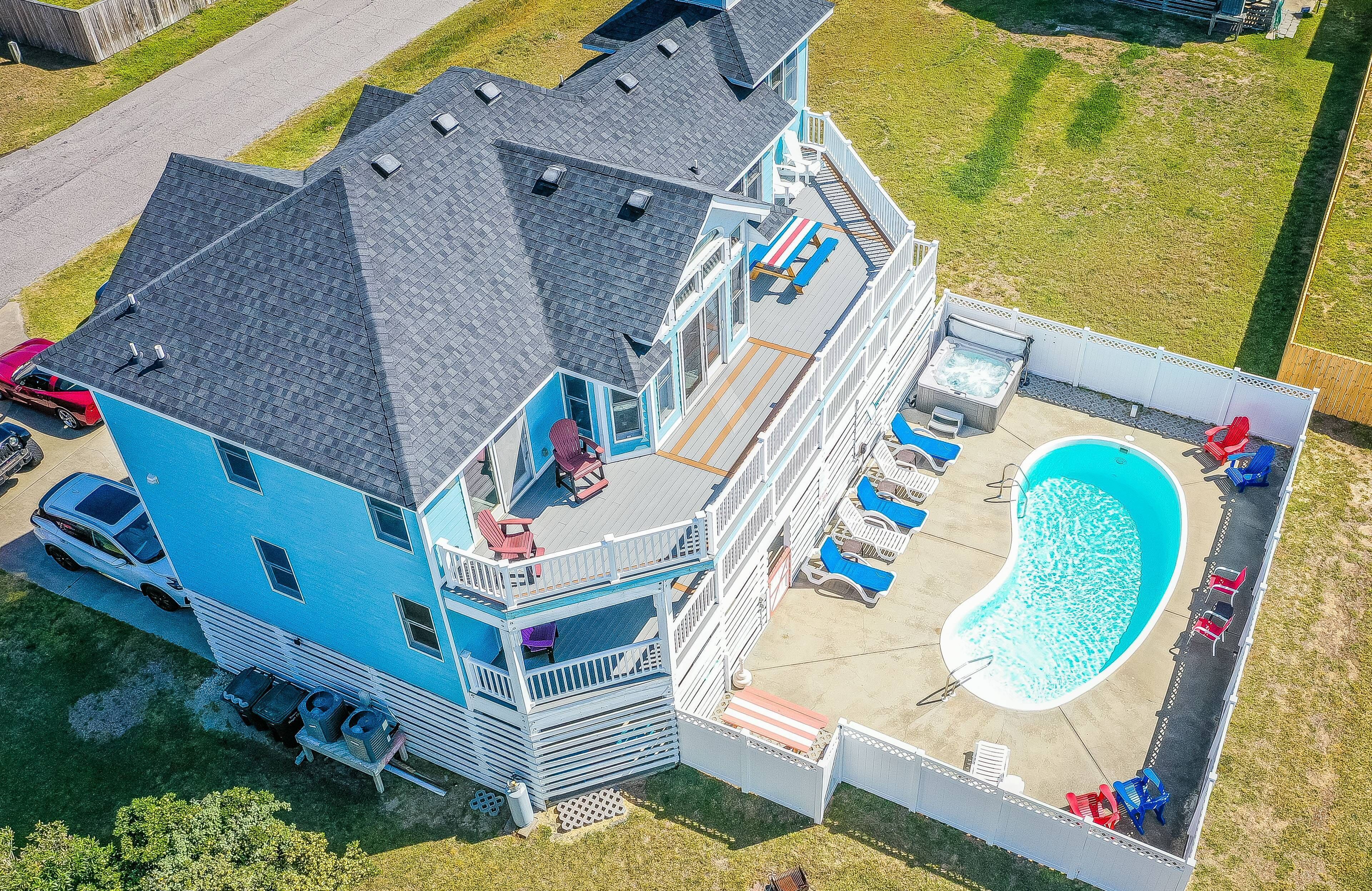 Una casa de dos pisos con un amplio balcón, piscina y jacuzzi.