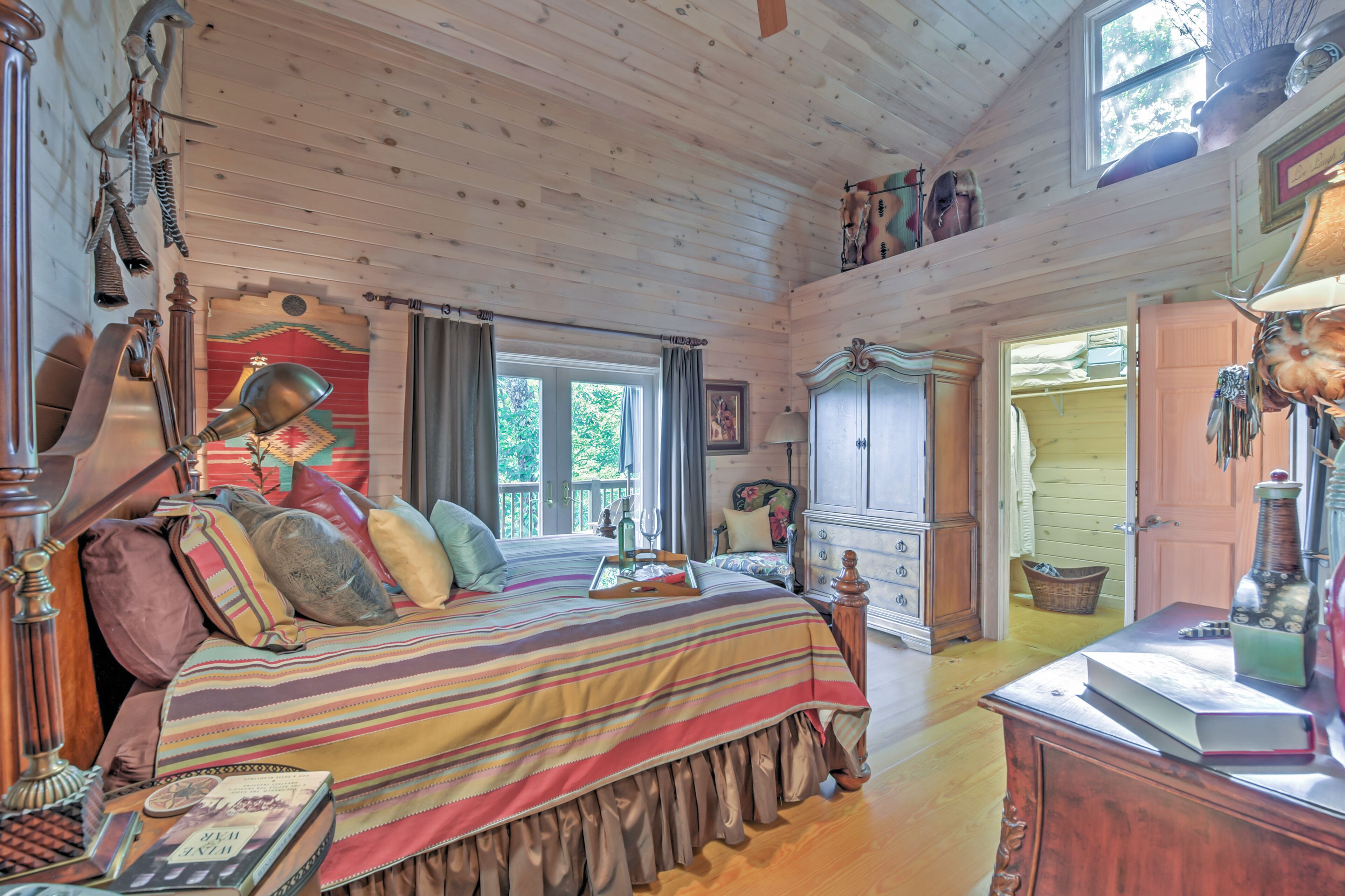 A cozy room with a large bed, wooden furniture, and a window with curtains.