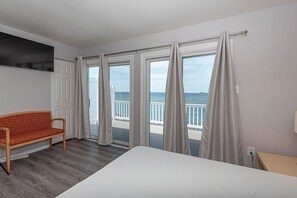 Une chambre d’hôtel avec un lit, un canapé et de grandes fenêtres équipées de rideaux.