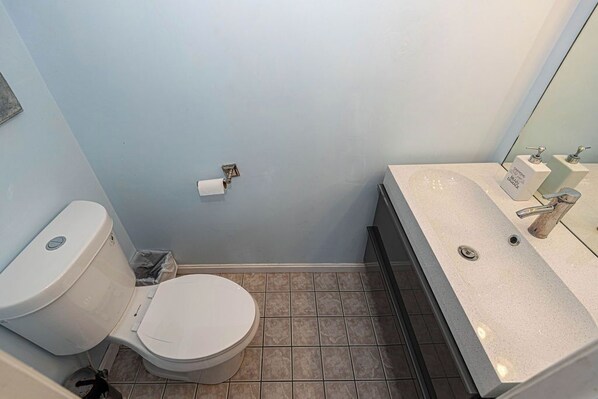 Une petite salle de bain avec des toilettes, un lavabo et un miroir.