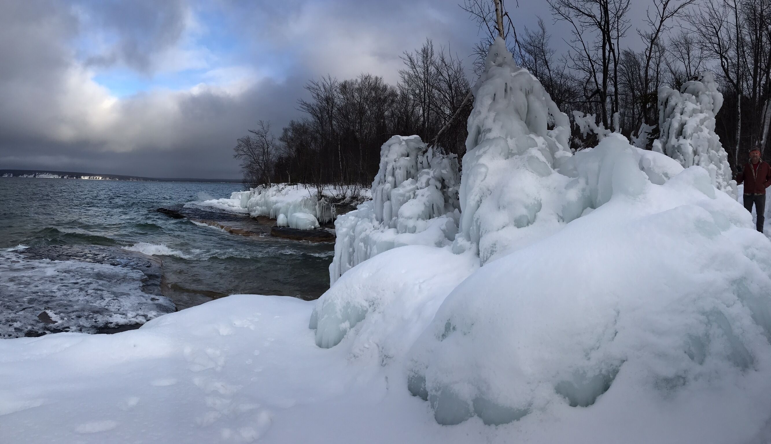 Un paisaje nevado con formaciones de hielo a lo largo de la orilla de un río.