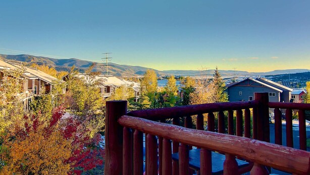 Un quartier résidentiel avec des maisons, une clôture en bois et une vue dégagée sur les montagnes lointaines.