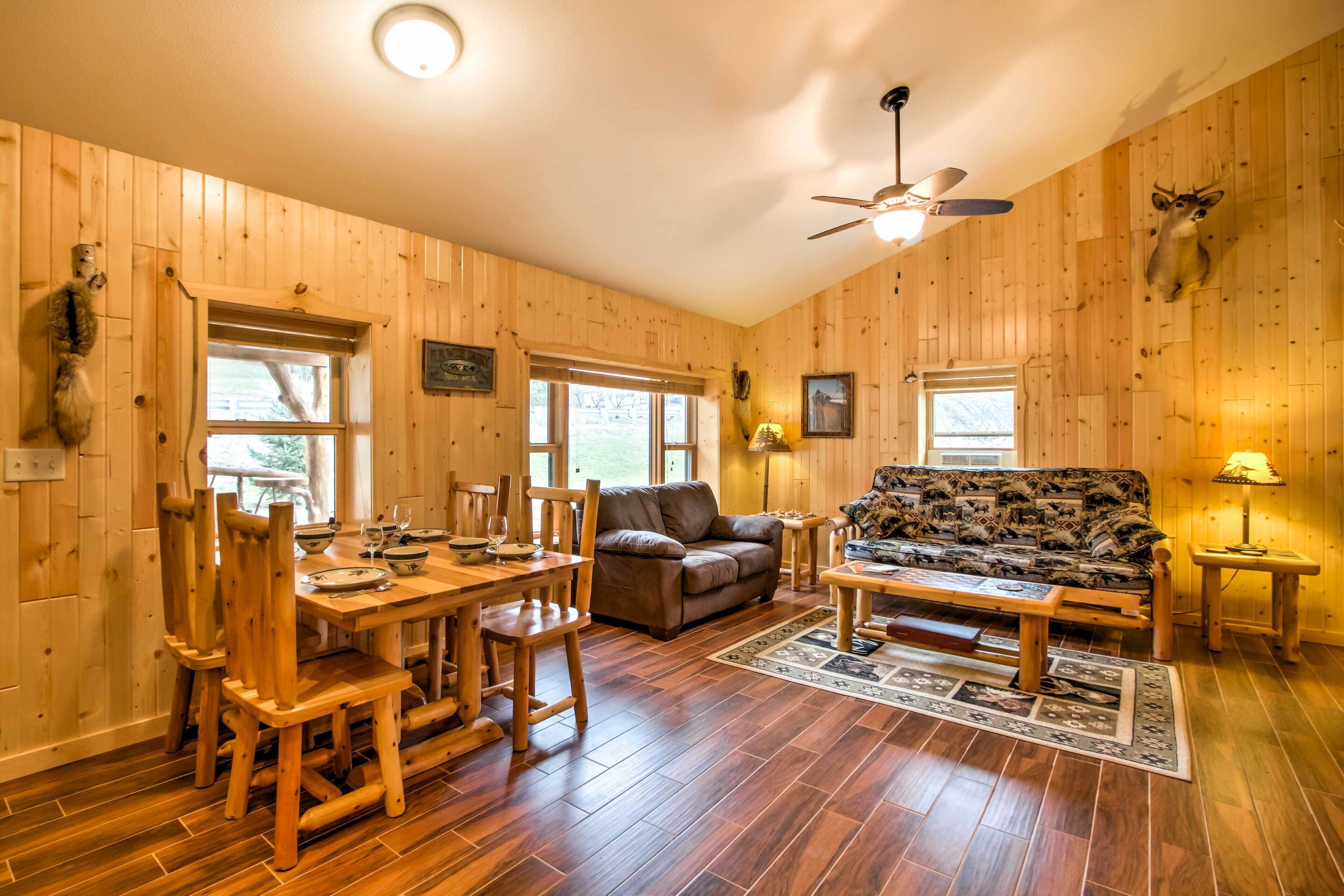 Un intérieur en bois comprenant une table à manger, des chaises, un canapé et un ventilateur de plafond.