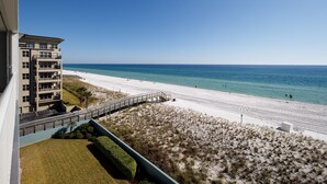Un hotel sulla spiaggia con vista sull'oceano, una spiaggia sabbiosa e una passeggiata sul mare.