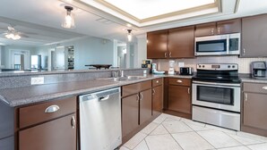 A modern kitchen with stainless steel appliances, a dishwasher, and a large island with a sink.