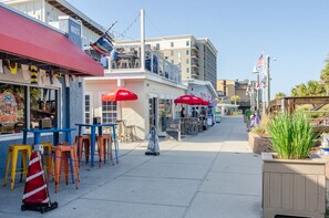 Dine al fresco in style with outdoor seating under shaded tables and umbrellas.