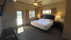 A hotel room with a bed, two bedside lamps, a ceiling fan, and a window with curtains. - Three Bedroom Condo @ Spring Brook Resort (Wisconsin Dells)