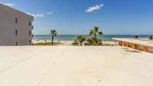 A beach view with a building, palm trees, and a clear sky. - Just Renovated, New Kitchen & Upgraded Bath - Free WiFi - Surf Song (Madeira Beach)