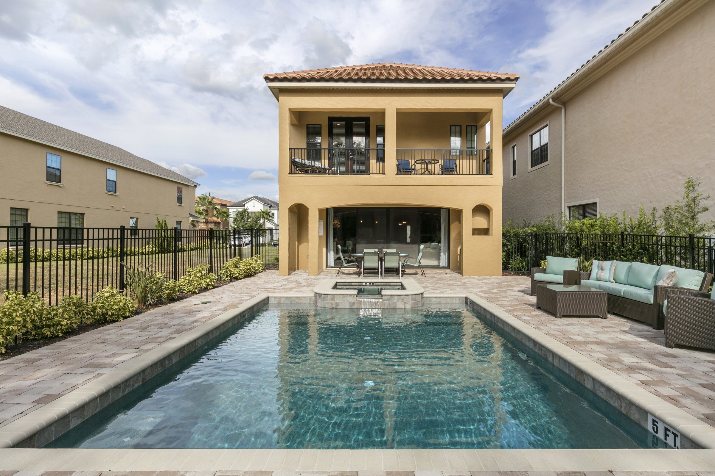 Un bâtiment à deux étages avec une piscine en premier plan.