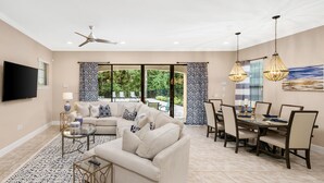 Un salon spacieux avec un canapé beige, une table basse et un coin repas comprenant une table et des chaises.