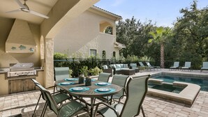 Une terrasse extérieure avec une piscine, des sièges et un barbecue.