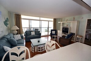 Living area - Stylish, spacious 2 bedroom oceanfront condo with owner provided WiFi, 3 flat screen televisions (all with HBO and Disney channels and blue ray players) , floral decor, and a deluxe balcony with a spectacular ocean view located uptown just steps to (Ocean City)