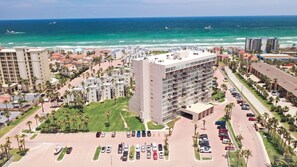Un hôtel situé sur la côte, avec plusieurs étages, un parking et une vue sur l’océan.