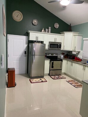 A kitchen with white cabinets, stainless steel appliances, and decorative plates on the wall.