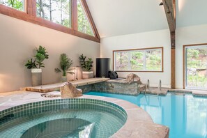 Une piscine avec un bord carrelé, des poutres en bois et des plantes en pot.