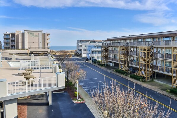 A coastal hotel with multiple floors, outdoor seating, and a view of the beach.