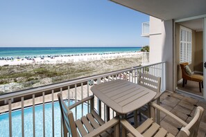Uma varanda com vista para uma praia e uma piscina.