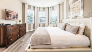 Ein Schlafzimmer mit einem großen Bett, einem Schminktisch und einem Deckenventilator.