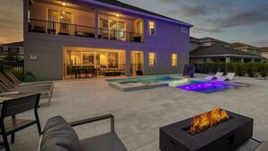 Ein modernes, zweistöckiges Haus mit Swimmingpool, Außenbereich und Feuerstelle.
