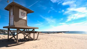 A lifeguard tower on a sandy beach with clear skies. - Spacious lower oceanfront located within walking distance of the Balboa Pier fun (Newport Beach)