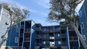 Un immeuble d’appartements à plusieurs étages, doté de balcons et d’une cour intérieure.