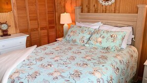 Une chambre à coucher avec un lit, une armoire en bois et un miroir au mur.