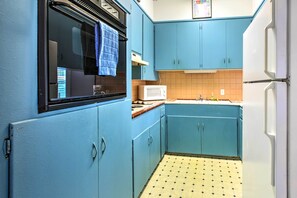 Kitchen with a refrigerator, microwave, and window.