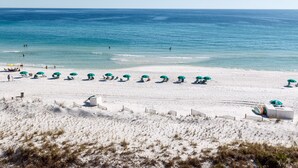 A beach with white sand, turquoise water, and green umbrellas. - GD 608: Seas the Gulf - Waves at Your Doorstep! (Fort Walton Beach)