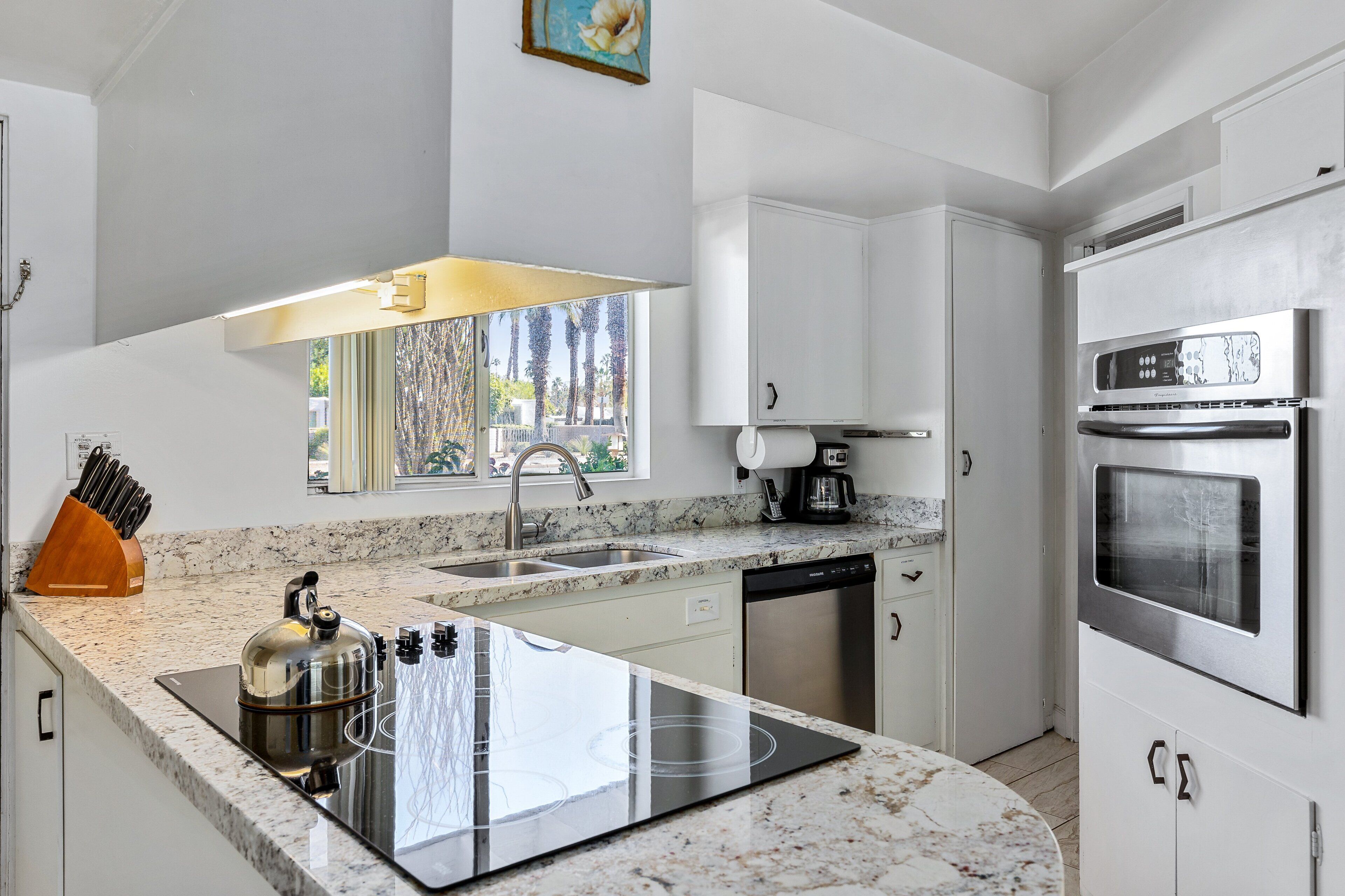 A modern kitchen with a built-in stove, dishwasher, and stainless steel appliances.