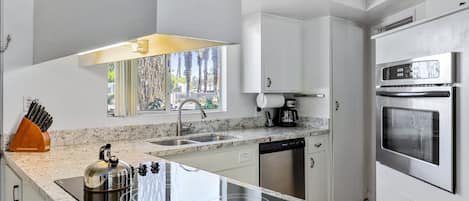 A modern kitchen with a built-in stove, dishwasher, and stainless steel appliances.