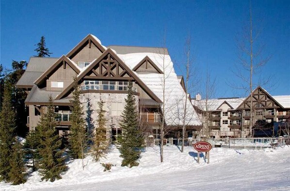 Un chalet à l’architecture symétrique, doté de nombreux balcons et d’une enseigne bien visible indiquant « ASPENS ».