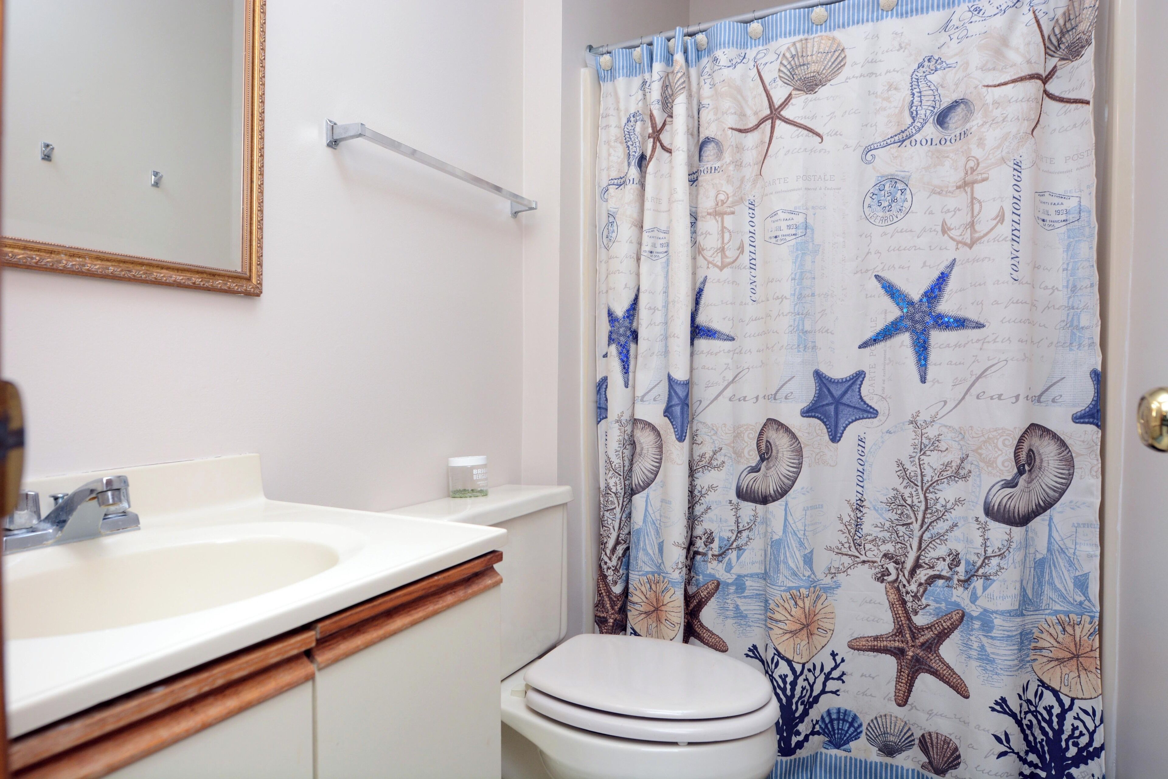 Un baño con lavamanos blanco, un espejo y un inodoro.