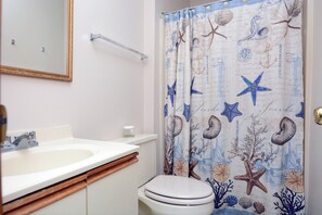 Een badkamer met een wit wastafel, een spiegel en een toilet.