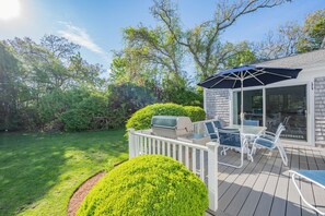 A deck with outdoor furniture, a grill, and a glass door leading to a covered area. - Walk to Beach, AC, Wifi, Central location (Harwich)