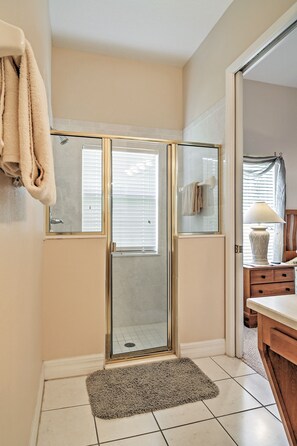 Une salle de bain avec une douche à parois de verre, un porte-serviettes, un lavabo et un meuble-lavabo avec un miroir.