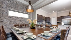 Un comedor con una larga mesa de madera dispuesta para seis personas, rodeada de sillas de madera oscura.