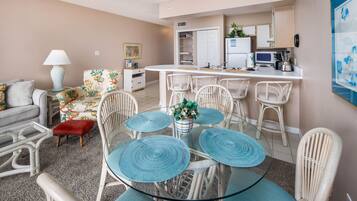 A compact living space with a dining area, kitchenette, and a sofa.