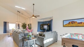 A living room with a sofa, coffee table, and foosball table.