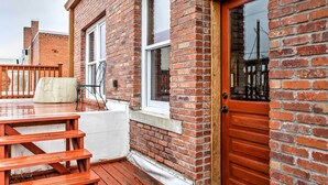 A brick building with a wooden deck, a door, and windows. - 1 Mi to UW: Historic Laramie Apt (Laramie)