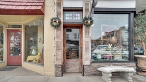 A storefront with a 'PRIVATE PROPERTY' sign, a bench outside, and a large window displaying various items. - 1 Mi to UW: Historic Laramie Apt (Laramie)