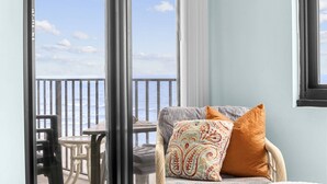 A balcony with a view of the ocean, a wicker chair, and a table with chairs. - *Fall into Savings-20% Off New Bookings thru 2026* (Garden City)
