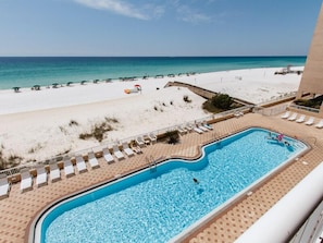 A pool with a view of a beach and ocean.