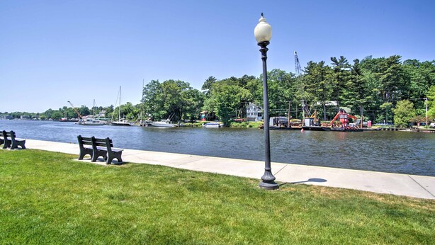 A riverside park with benches, a lamp post, and boats in the background. - Historic Loft w/ Private Deck, 2 Blocks to Dtwn (Saugatuck)