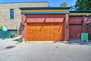 A brick building with a large garage door and a smaller door. - Historic Loft w/Private Deck |2 Blocks to Downtown (Saugatuck)