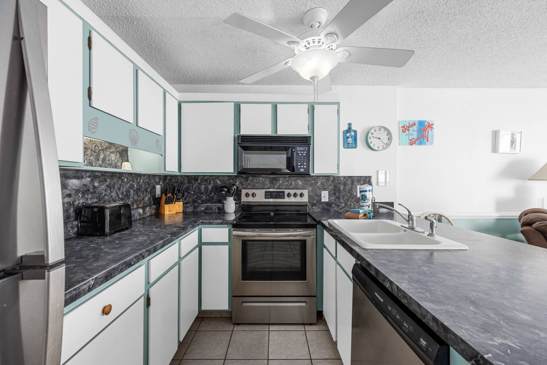 A compact kitchen with a microwave, stove, and dishwasher.