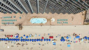 An aerial view of a beach with multiple swimming pools, sun loungers, and umbrellas. - *Fall into Savings-20% Off New Bookings thru 2026* (Murrells Inlet)