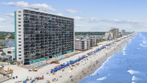 A high-rise hotel with multiple floors, a beachside location, and a long promenade with umbrellas. - *Fall into Savings-20% Off New Bookings thru 2026* (Murrells Inlet)
