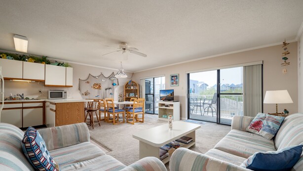 Un espacio habitable amplio con un conjunto de sofás, una mesa de comedor y una cocina.