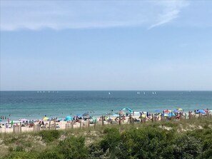 Een strand met meerdere parasols en mensen.